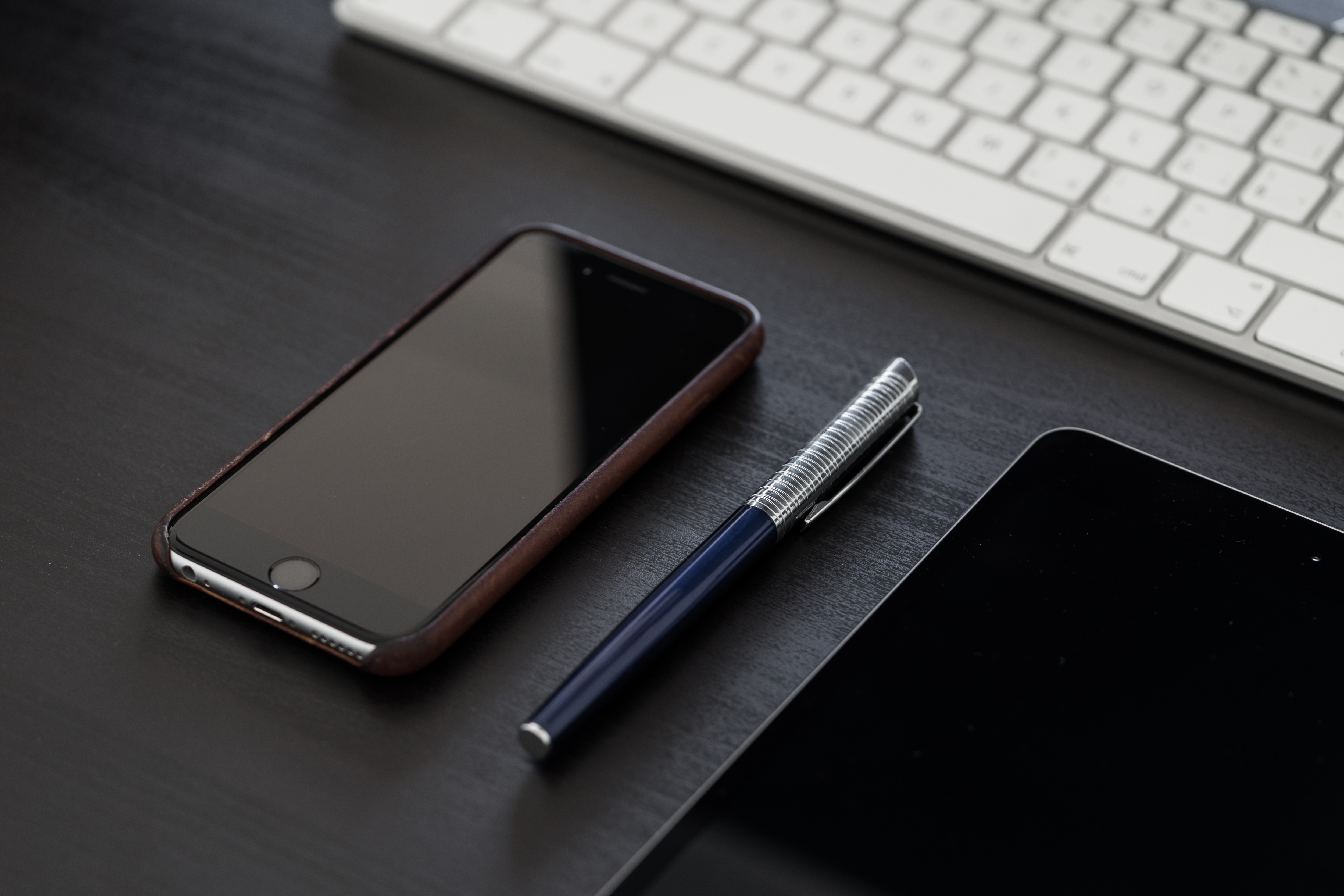 black-iphone-on-black-office-desk-picjumbo-com (1)